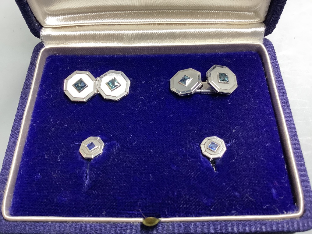 A cased four piece white metal (stamped 750) and sapphire set octagonal dress stud set, comprising a pair of cufflinks and two studs